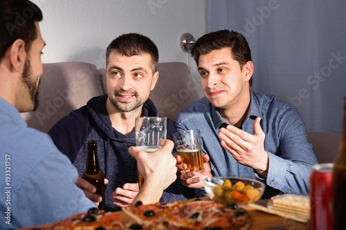 Friendly meeting in men company over beer with pizza photo