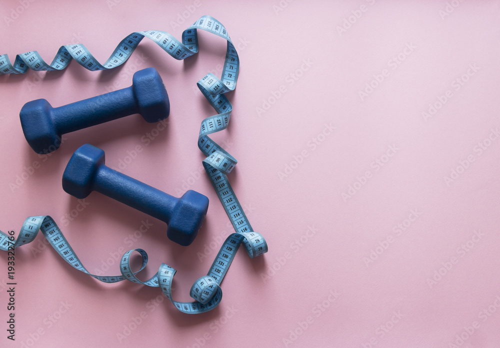 on a pink background dumbbells blue and flying centimeter figure sport soft light on a pink background dumbbells blue and flying centimeter figure sport soft light