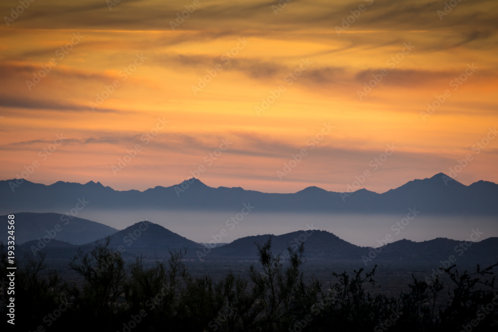 Colorful sunset with layers of mountains and mist