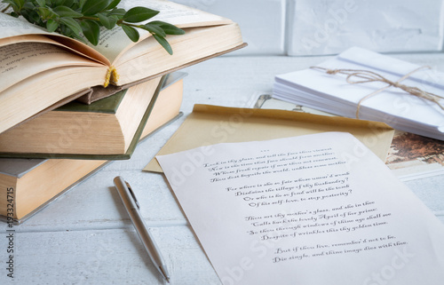 Shakespeare verse printed on beige paper, old books, cards, envelopes on a white, textured wooden background photo