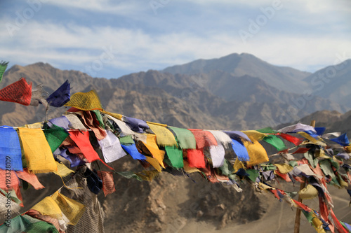 buddyjskie flagi modlitewne rozpięte na skałach kołyszace się na wietrze
