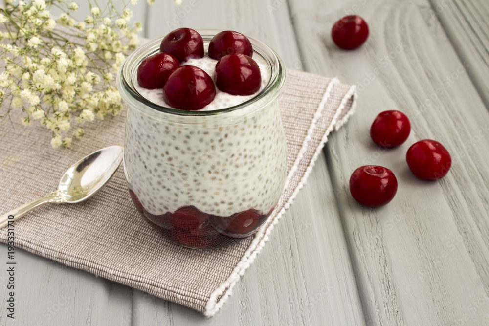 Pudding with chia and cherry on the grey wooden background Pudding with chia and cherry on the grey wooden background