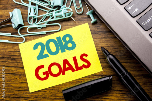 Handwriting Announcement text showing 2018 Goals. Business concept for New Yer resolutions written on sticky note paper on the wooden background next to the laptop keyboard With marker photo