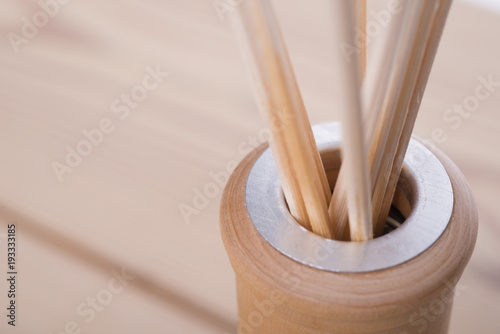 close up of the neck of a glass bottle with aroma liquid and reed sticks