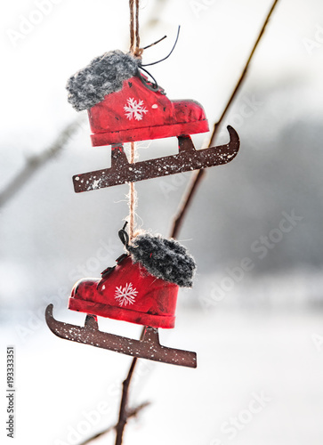 Vintage decorative red skates on a winter background. Selective focus. Christmas mood.