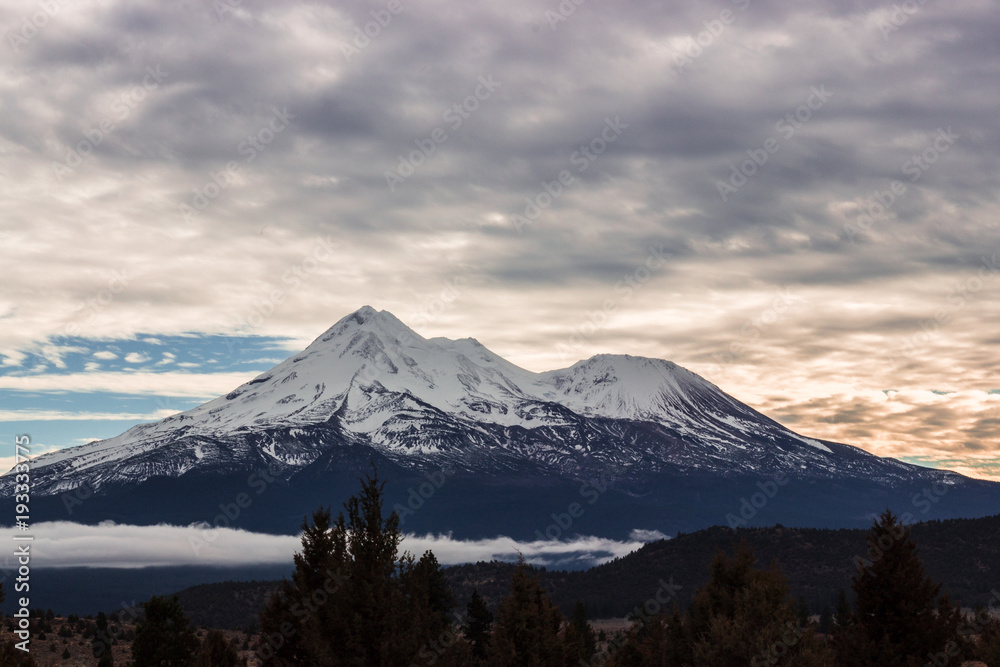 Mount Shasta in the clouds at sunset.