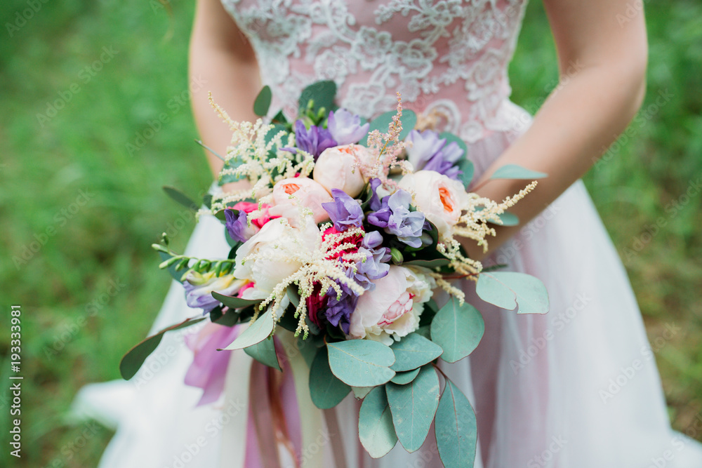 A bride in a white dress is holding a beautiful wedding bouquet. A bride in a white dress is holding a beautiful wedding bouquet.