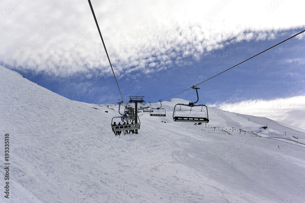 Snowy landscape of  Sierra Nevada with blue sky,  chairlift  and white mountains with snow..