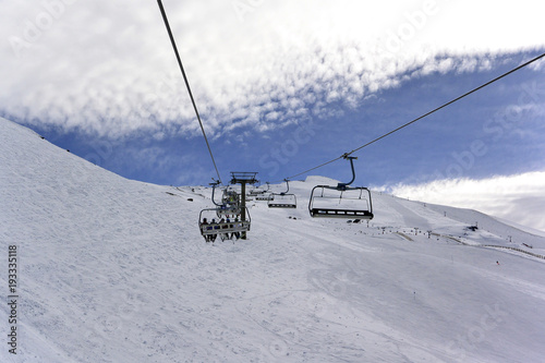 Snowy landscape of Sierra Nevada with blue sky, chairlift and white mountains with snow..