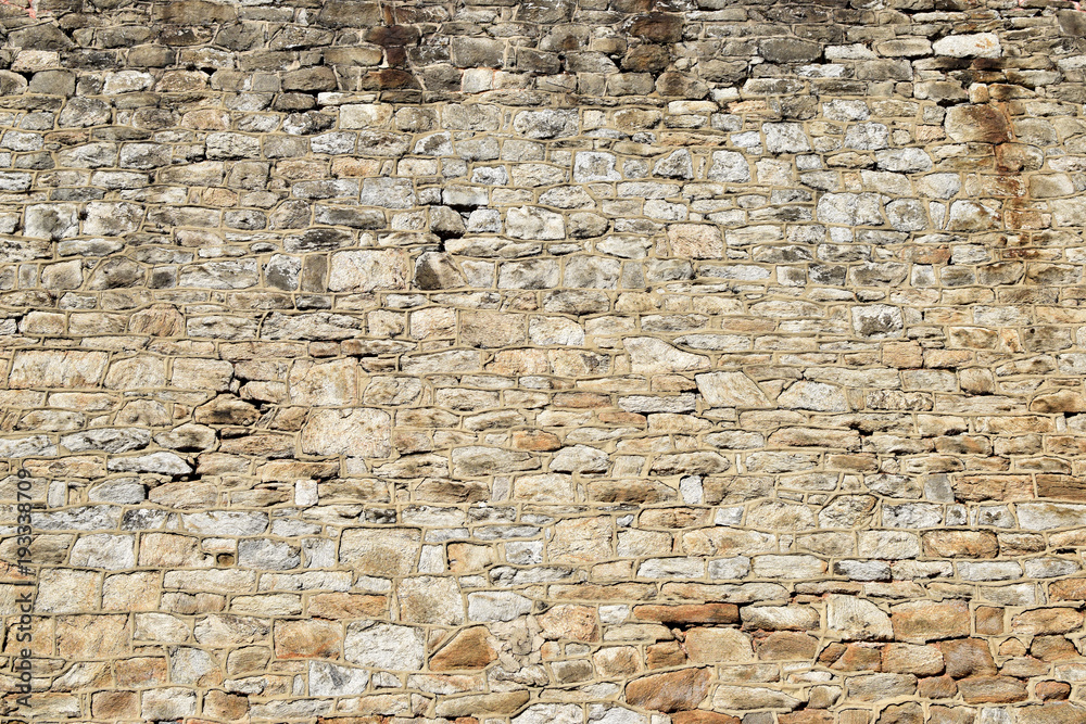 Fototapeta premium Irregular cobblestone wall with moss and grime closeup texture background