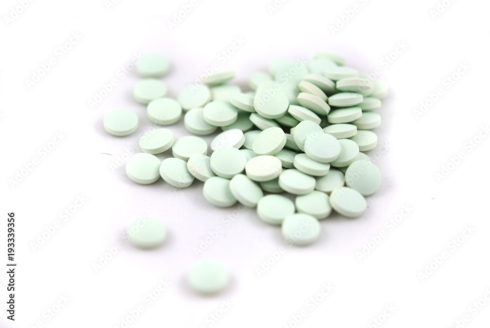 Light green round tablets closeup o white background Light green round tablets closeup o white background