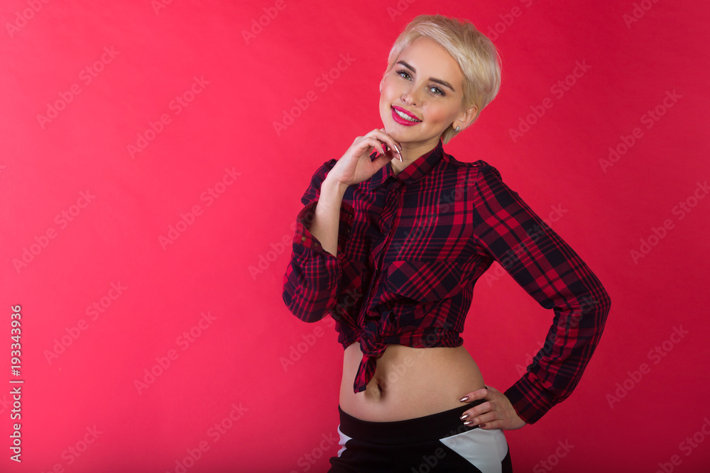 Fototapeta premium beautiful young girl with snow-white smile and healthy teeth with short hairdo to shirt on red background