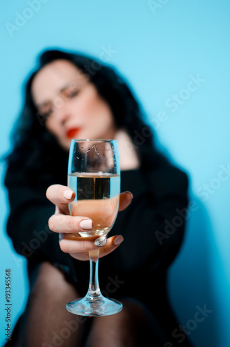 Business woman Holding a Champagne Glass with the camera focus on the glass