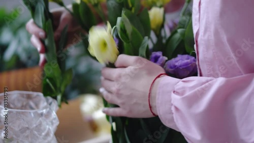 Young woman working with yellow and purple flowers. Closeup