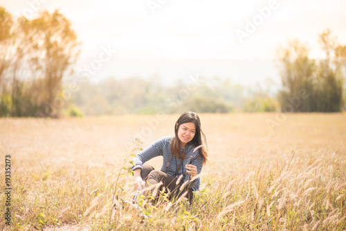 Asian woman sitting on the grass field outdoor travel