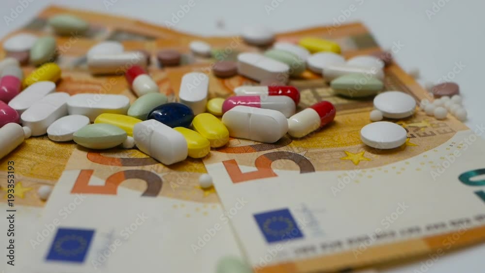 close up, colored pills rotating on 50s euro banknotes from the right side close up, colored pills rotating on 50s euro banknotes from the right side