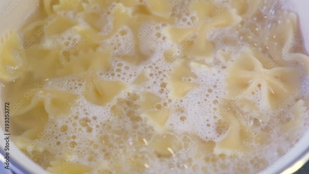 Boiling pasta in a saucepan. Farfalle - bow shaped pasta 
