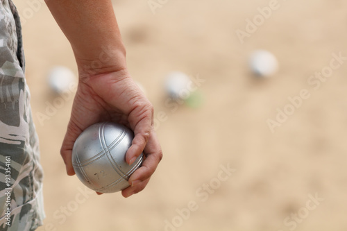 Hand of female boule holding boule or petanque ball on match photo