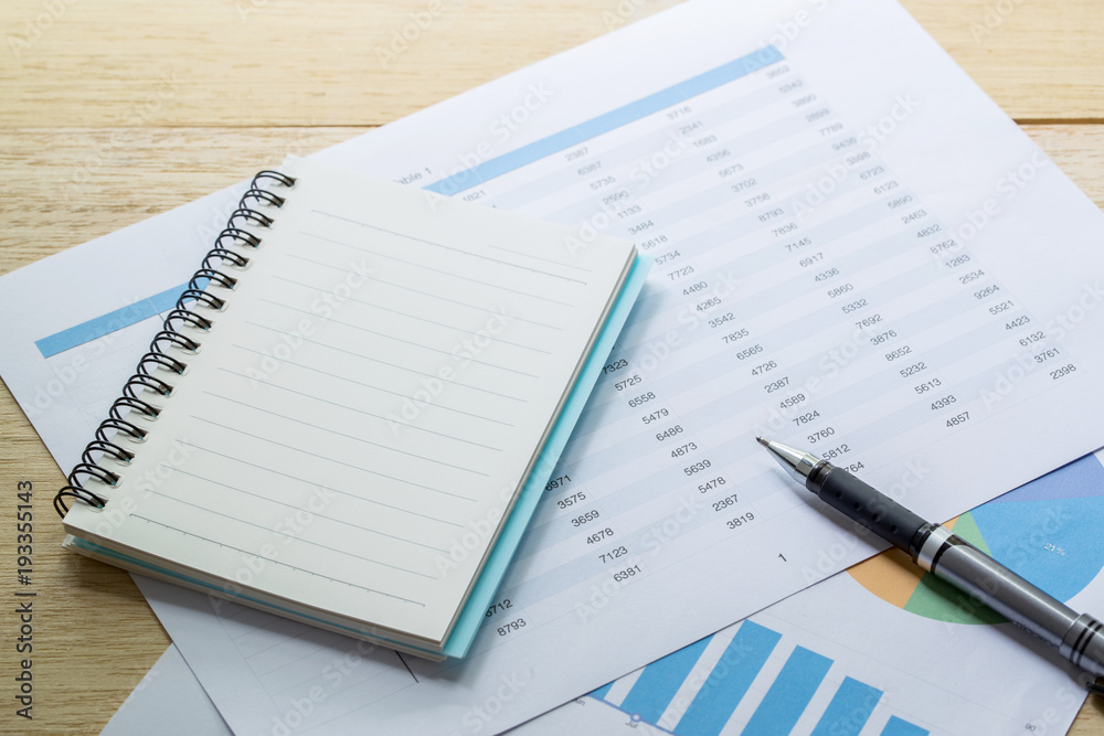 financial charts and Business graphs, note and pen on the table financial charts and Business graphs, note and pen on the table