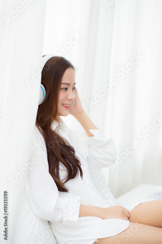 Free Download Beautiful asian young woman enjoy listen music with headphone while sitting in bedroom, relax girl with earphone internet online, leisure and technology concept. - GFXLoad