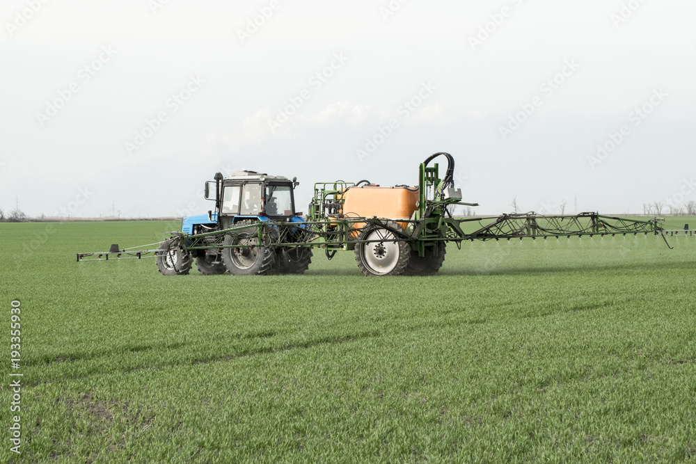 Fototapeta premium Tractor with a spray device for finely dispersed fertilizer.