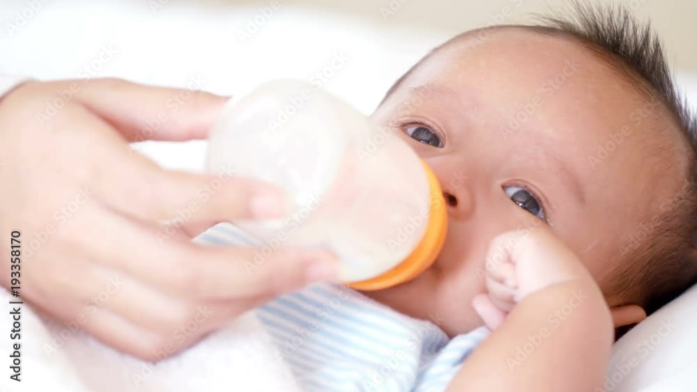 Little cute Asian baby drinking milk from a bottle. Little cute Asian baby drinking milk from a bottle.