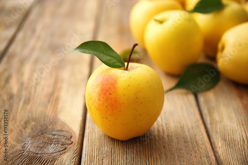 Ripe yellow apple on wooden table