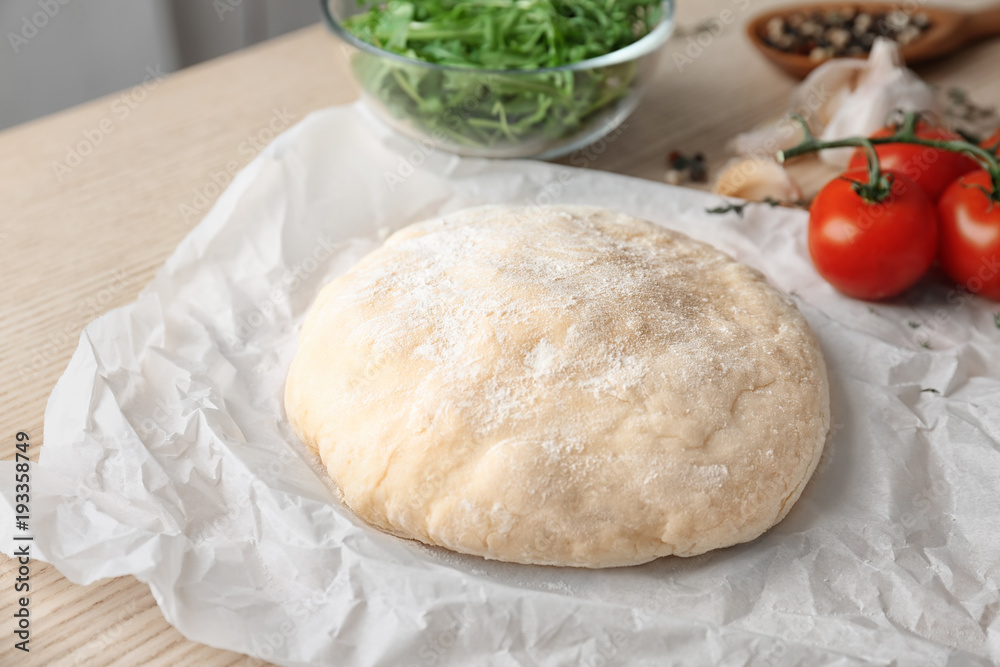 Raw dough with ingredients for pizza on kitchen table Raw dough with ingredients for pizza on kitchen table