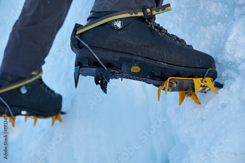 Quadro em tela Crampons close-up on his feet ice climber, climber on a frozen waterfall