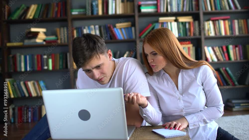Male And Female College Students Working On Laptop In Library. 4 k. Two Students Working On Laptop In College Library