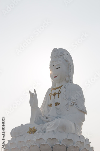 guan yin statue sunset in wat hyuaplakang chiang rai Thailand photo