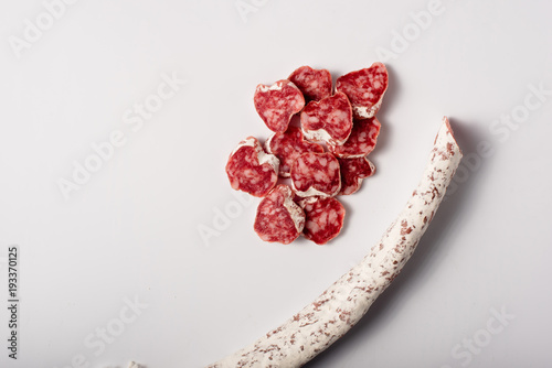 Spanish sliced moldy salami isolated on white photo
