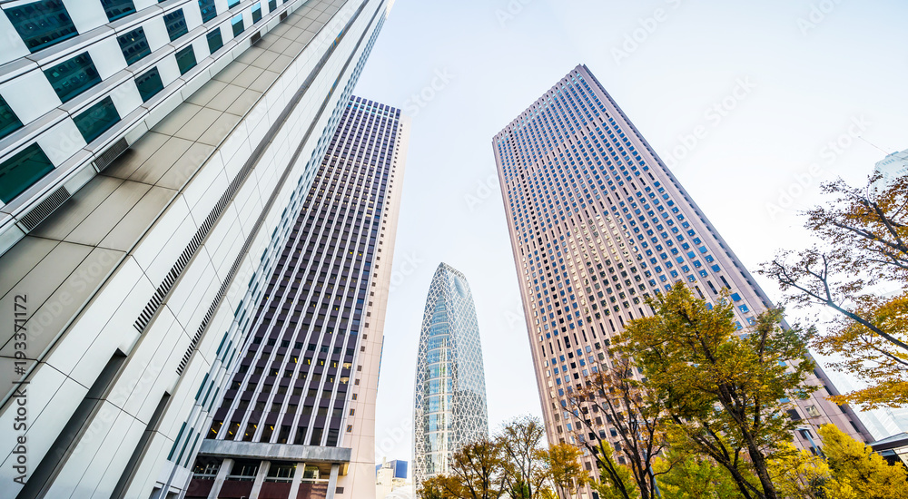 Asia Business concept for real estate and corporate construction - looking up view in financial district, the silhouettes of skyscrapers reflect blue sky in Tokyo, Japan. Asia Business concept for real estate and corporate construction - looking up view in financial district, the silhouettes of skyscrapers reflect blue sky in Tokyo, Japan.