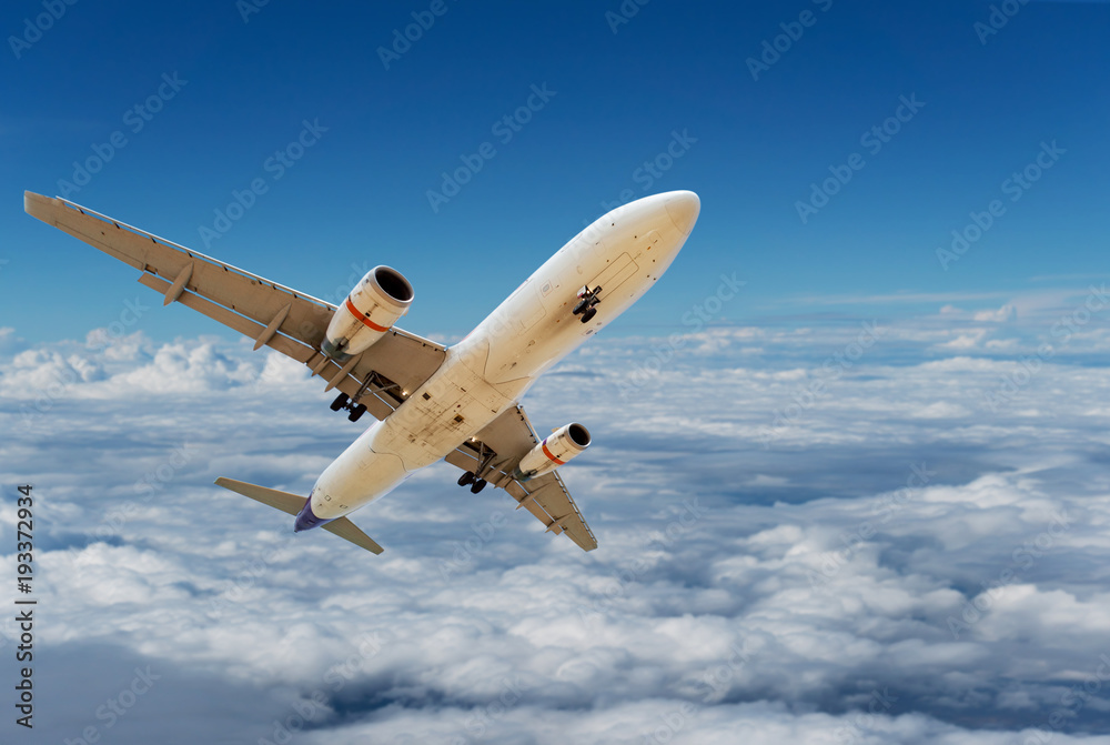 Obraz premium Commercial airplane flying above clouds and clear blue sky over beautiful scenery nature background,concept business travel and transportation background.