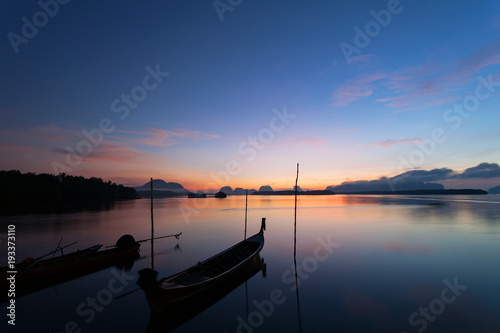 Longtail boat with coastal fishing village,Beautiful scenery view in morning sunrise over sea and mountain at phang - nga thailand