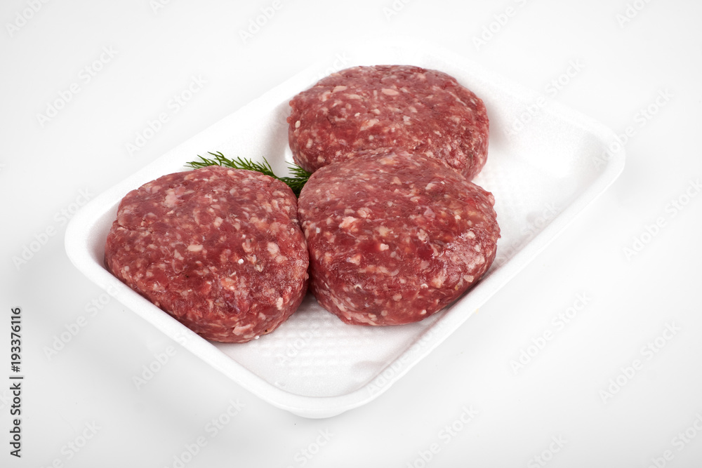 Tray with raw beef burgers isolated on white background