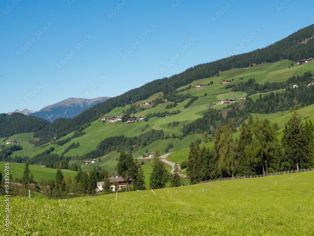View of mountain peaks and green meadow in summer landscape of Dolomiti Alps, Italy