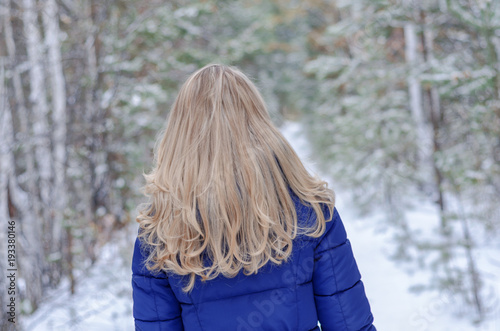 a girl with blond hair is standing with her back