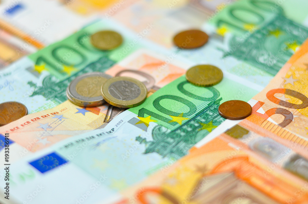 Euro coins over paper euro banknotes. Euro money banknote, business and finance concept Euro coins over paper euro banknotes. Euro money banknote, business and finance concept