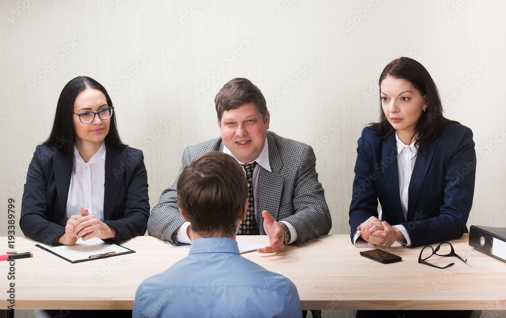 Young man during job interview and members of managemen Young man during job interview and members of managemen