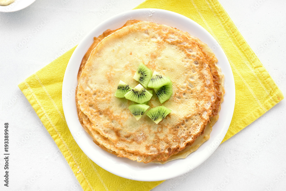 Homemade crepes decorated with kiwi slices Homemade crepes decorated with kiwi slices
