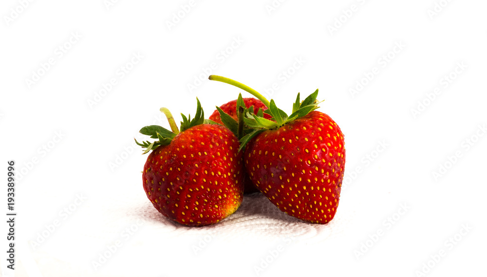 Three Red strawberries on tissue paper on white background Three Red strawberries on tissue paper on white background