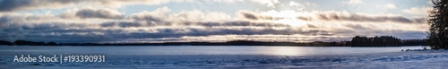 View of the winter lake under the snow and sunset