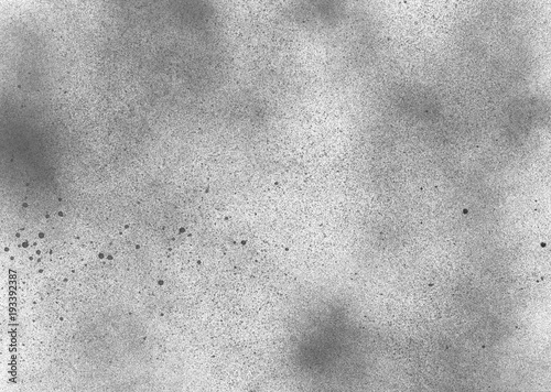 Subtle grain texture. Abstract black and white gritty grunge background. Dark paint spray particles on paper