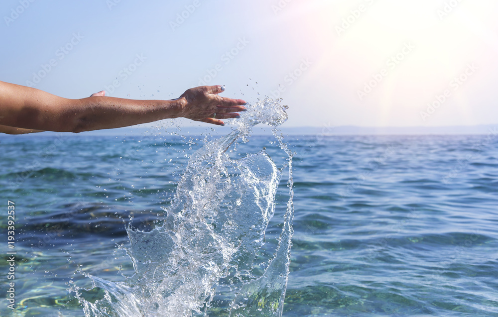 Women's hands do the spray of the sea.