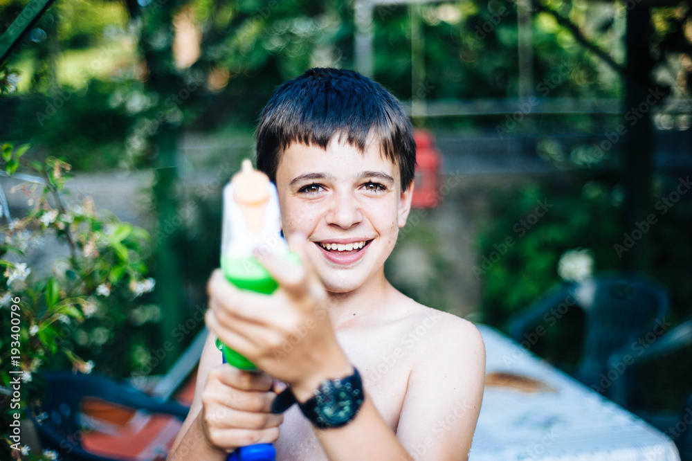 children play in the garden with guns and water rifles on a sunny summer day children play in the garden with guns and water rifles on a sunny summer day