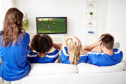 football fans watching soccer on tv at home