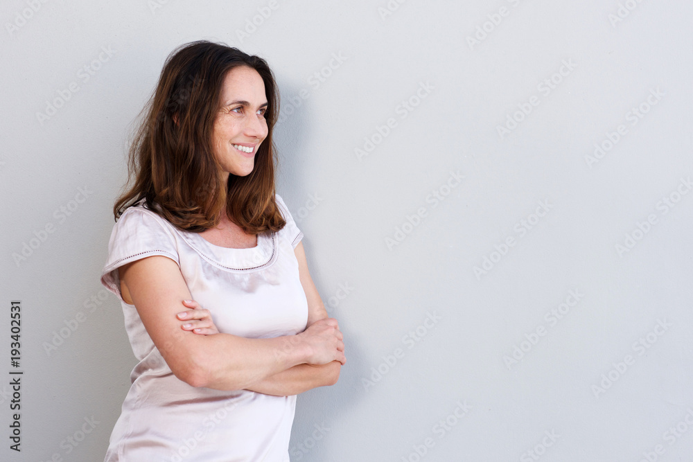 smiling older woman leaning against white wall smiling older woman leaning against white wall