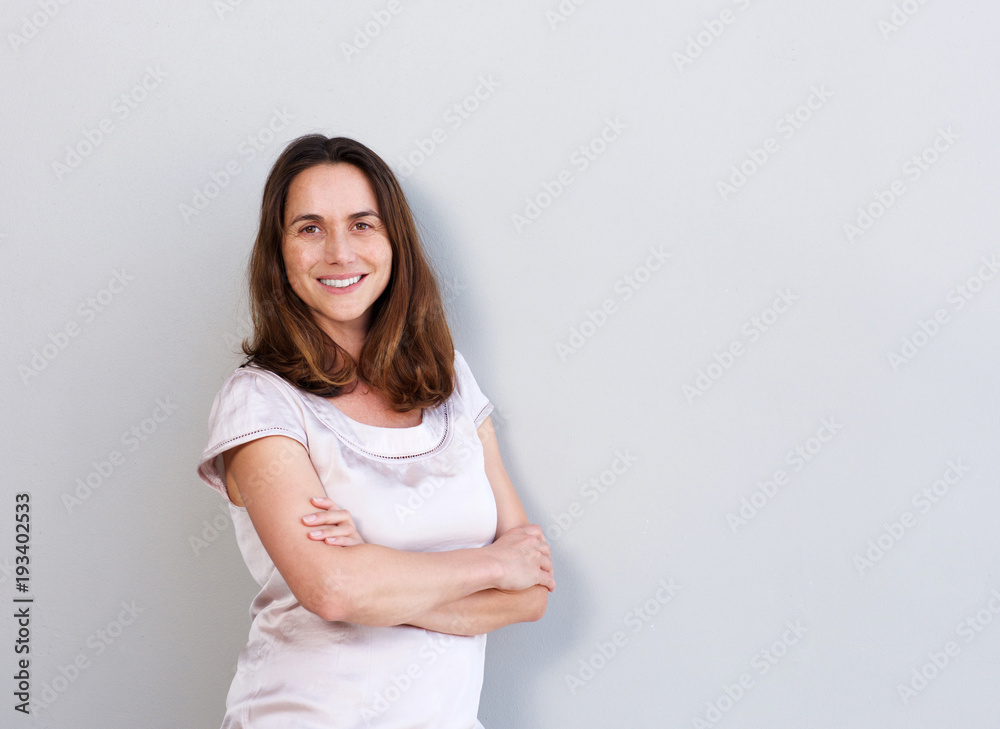 smiling middle aged woman against white wall smiling middle aged woman against white wall