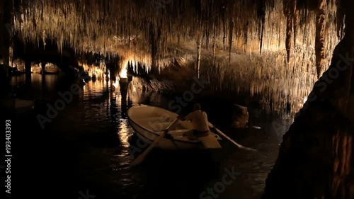 MAJORCA, SPAIN Tourists float on a boat on the underground lake in the famous stalactite caves of Dragon (Cuevas del Drach)